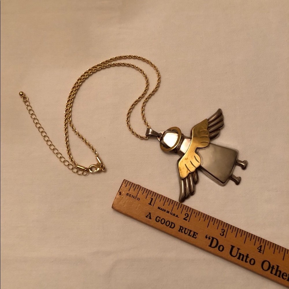 Angel pendant with gold tone chain. Two tone metal
